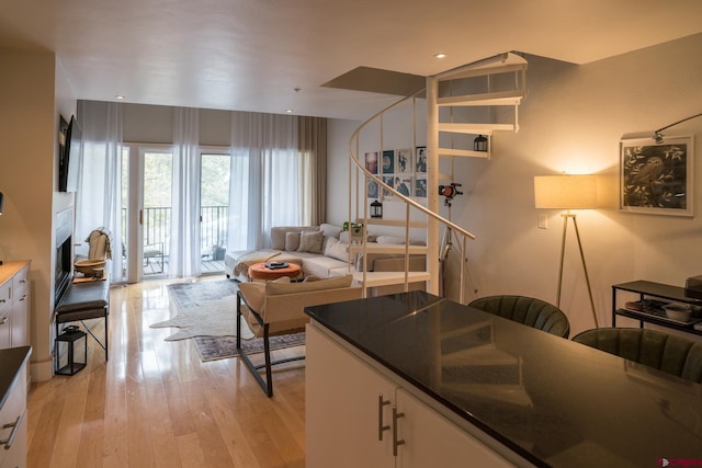 living area with light wood-type flooring and stairs