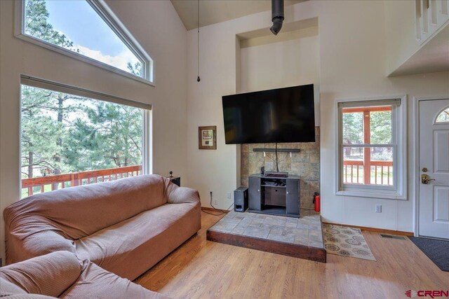 living area with high vaulted ceiling and wood finished floors