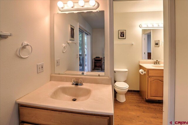 bathroom featuring toilet, wood finished floors, and vanity