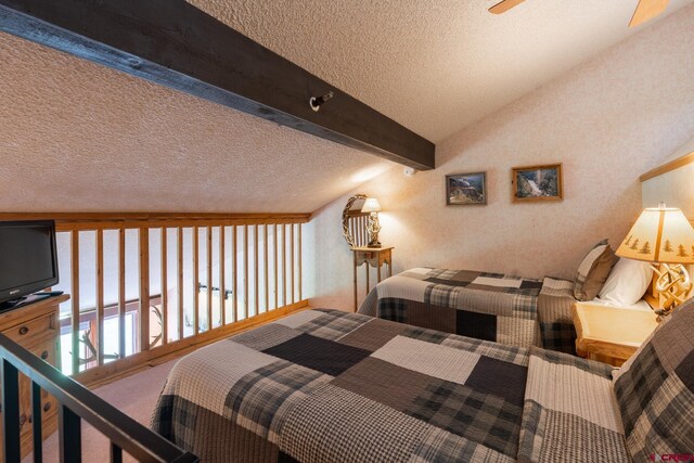 bedroom featuring a textured ceiling and vaulted ceiling with beams