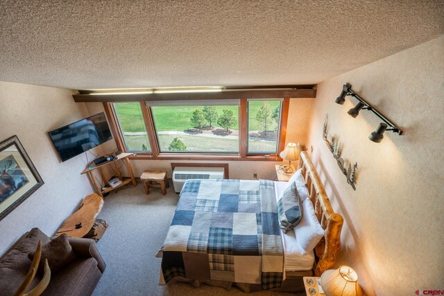 living room featuring an AC wall unit, carpet flooring, and a textured ceiling