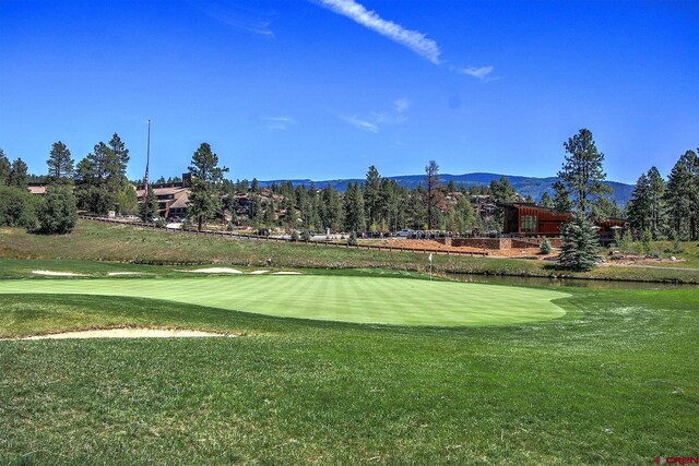 surrounding community with a yard, a water and mountain view, and golf course view