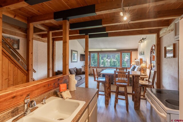 dining room featuring wood ceiling, wood finished floors, and beamed ceiling