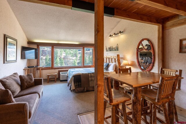 bedroom with carpet floors, lofted ceiling with beams, and a textured wall
