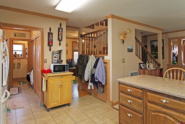 kitchen with light tile patterned flooring, baseboards, and ornamental molding