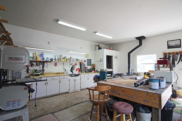 interior space featuring light countertops, white cabinets, electric panel, and open shelves