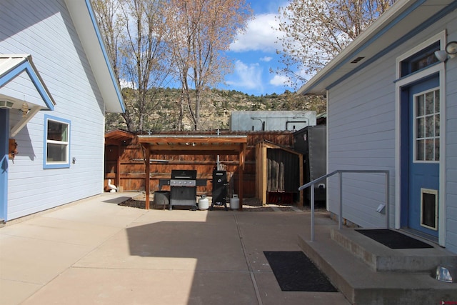 view of patio with area for grilling and fence