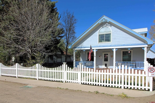 view of front of property featuring a porch and a fenced front yard