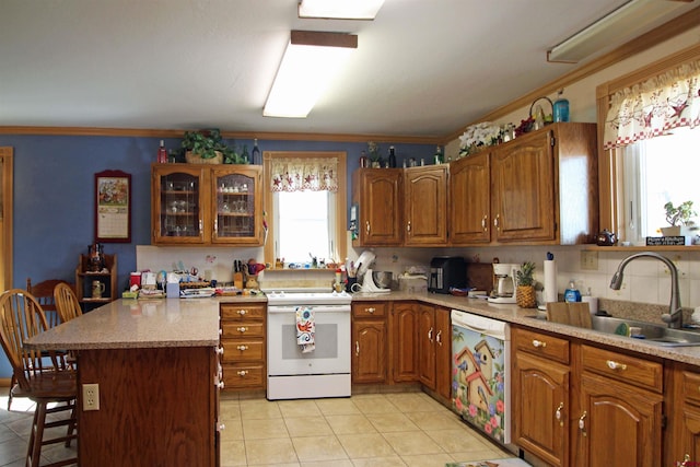 kitchen with a sink, a kitchen breakfast bar, brown cabinetry, and white appliances
