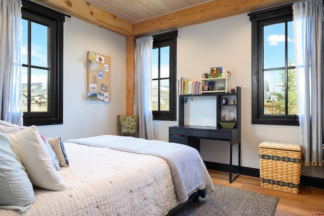 bedroom featuring wooden ceiling, baseboards, and wood finished floors