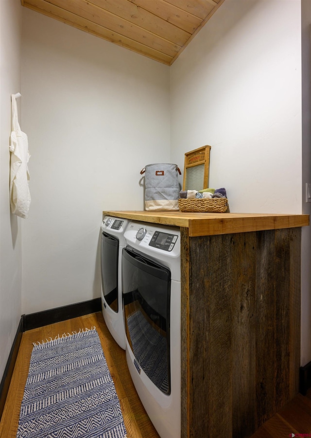 laundry area with laundry area, baseboards, wood finished floors, washing machine and dryer, and wood ceiling