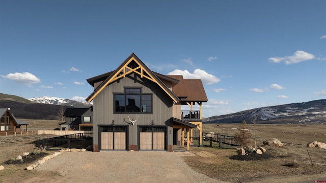 96 Chestnut Ln, Crested Butte, CO 81224 - view of front of home with a garage, fence, a mountain view, and dirt driveway