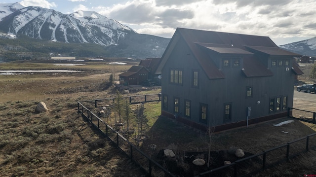 view of home's exterior featuring fence and a mountain view