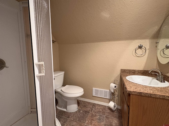 bathroom with visible vents, vanity, baseboards, toilet, and a textured wall
