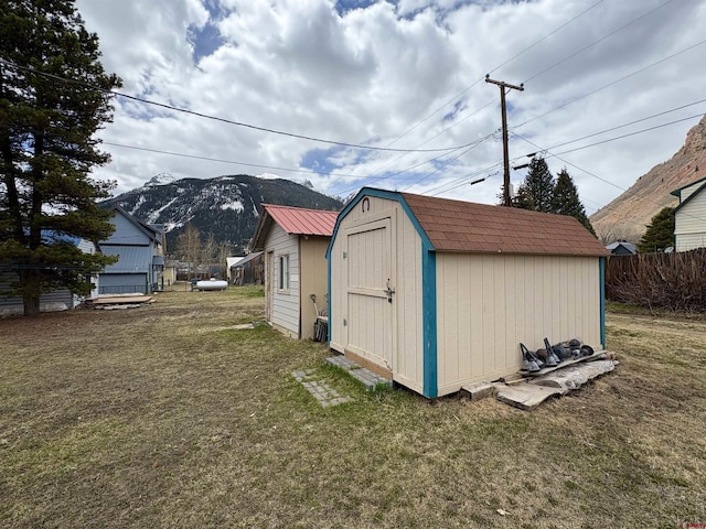 view of shed with a mountain view and fence