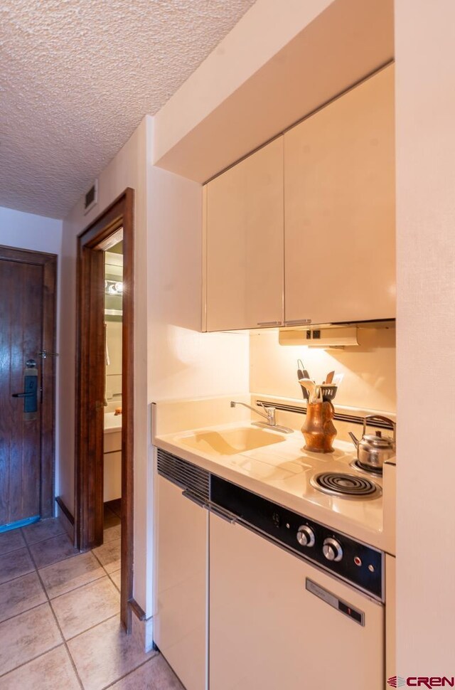 314 N Tamarron Dr Unit 215, Durango, CO 81301 - kitchen featuring light tile patterned flooring, light countertops, white cabinetry, a textured ceiling, and a sink