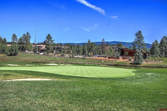 surrounding community with a yard, a water and mountain view, and golf course view
