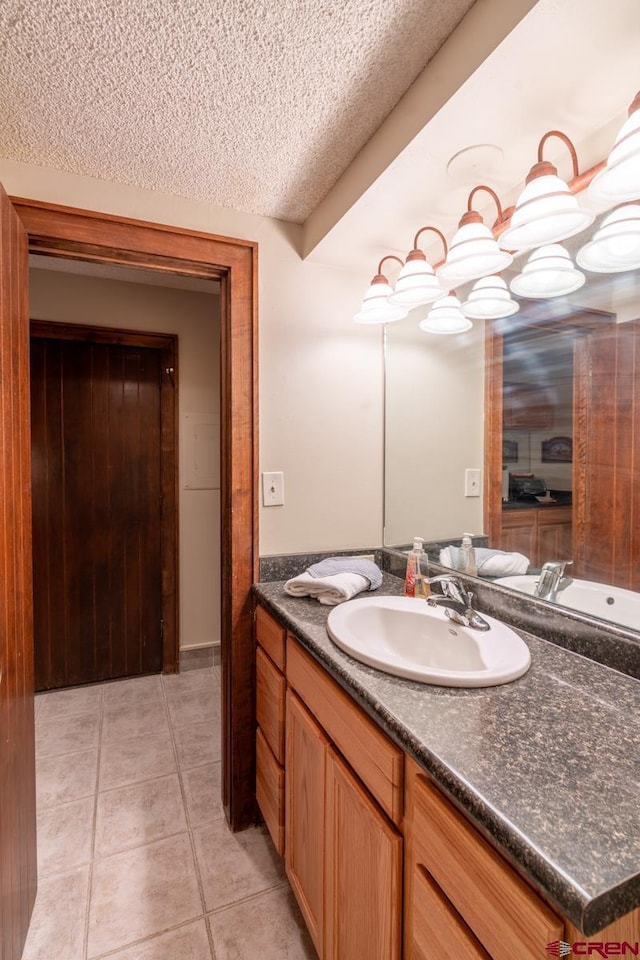 bathroom with vanity, tile patterned floors, and a textured ceiling