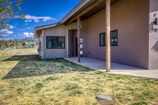 2785 Rock Rd Unit A, Pagosa Springs, CO 81147 - view of exterior entry featuring a yard, a patio, stucco siding, and a mountain view