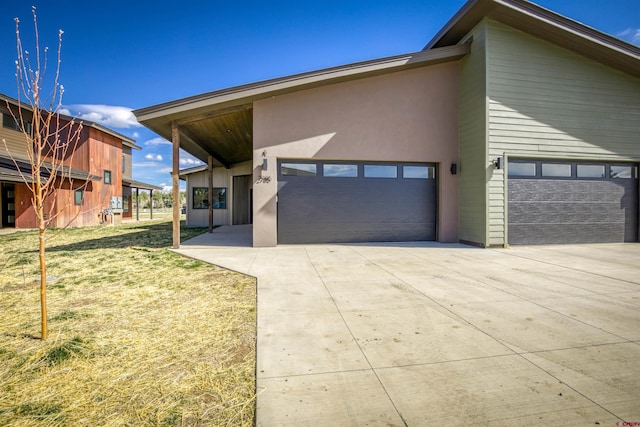 2785 Rock Rd Unit A, Pagosa Springs, CO 81147 - view of front of house featuring a garage, stucco siding, a front yard, and concrete driveway