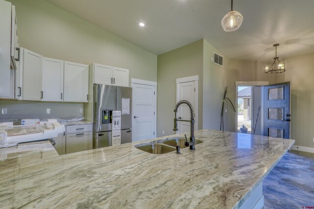 2785 Rock Rd Unit A, Pagosa Springs, CO 81147 - kitchen with visible vents, stainless steel fridge with ice dispenser, light stone counters, a sink, and hanging light fixtures