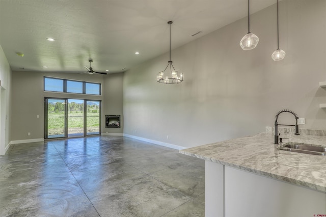 2785 Rock Rd Unit A, Pagosa Springs, CO 81147 - kitchen featuring a sink, finished concrete flooring, baseboards, open floor plan, and a towering ceiling