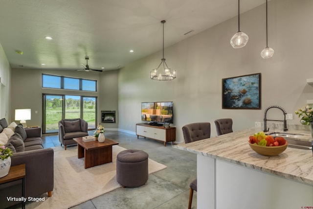 2785 Rock Rd Unit A, Pagosa Springs, CO 81147 - living area with baseboards, high vaulted ceiling, recessed lighting, concrete floors, and ceiling fan with notable chandelier