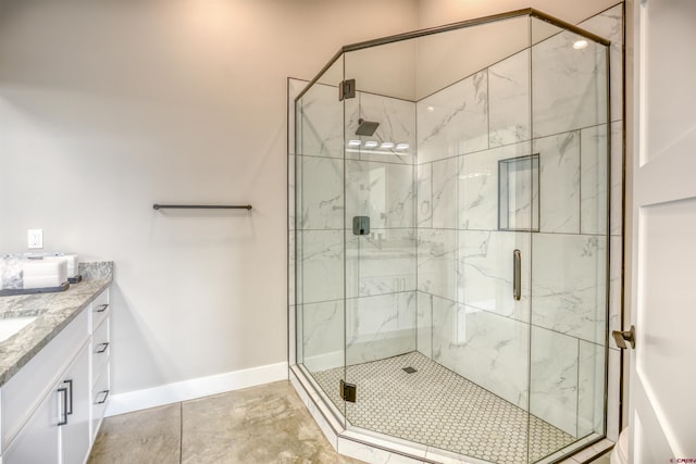 full bathroom with vanity, baseboards, and a stall shower
