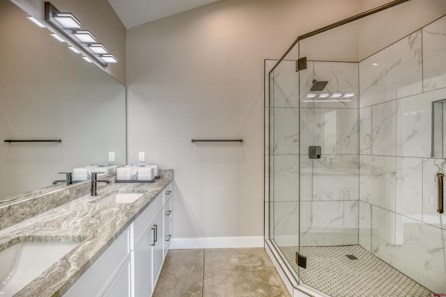 full bath featuring double vanity, baseboards, a sink, and a marble finish shower