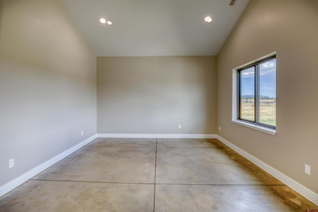 unfurnished room with baseboards, vaulted ceiling, recessed lighting, and finished concrete floors