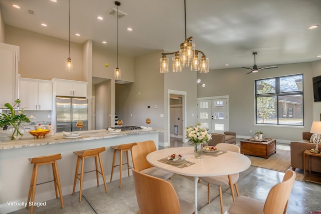 dining area featuring visible vents, a ceiling fan, a high ceiling, and recessed lighting