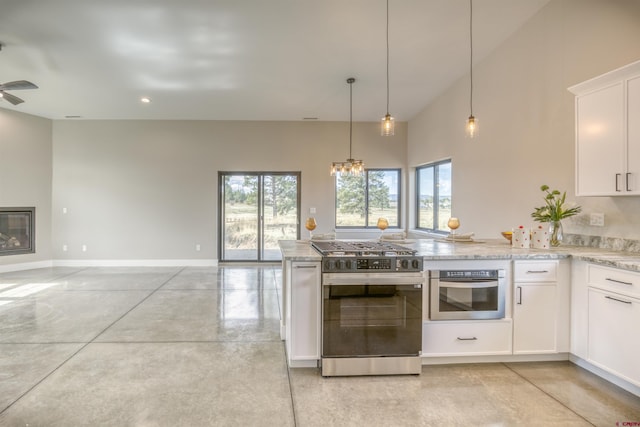 kitchen featuring a peninsula, open floor plan, white cabinets, light stone counters, and stainless steel appliances