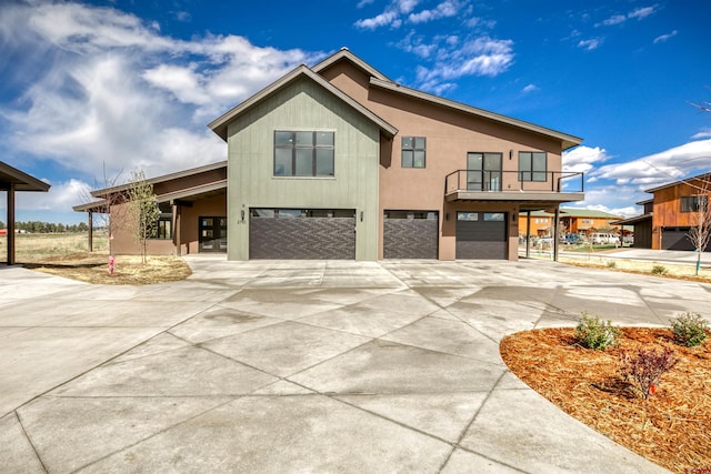view of front of house featuring a garage, a balcony, and concrete driveway