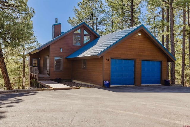 exterior space featuring a chimney and metal roof