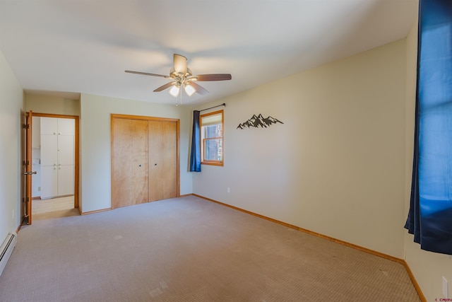 unfurnished bedroom with light carpet, baseboard heating, a ceiling fan, baseboards, and a closet