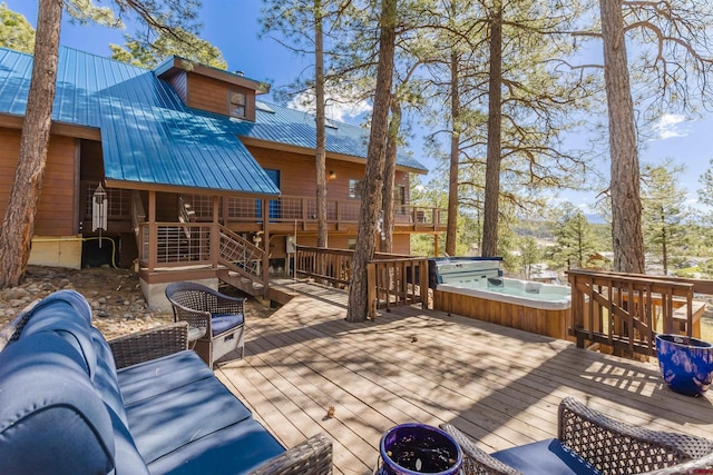wooden deck with an outdoor hot tub and stairs
