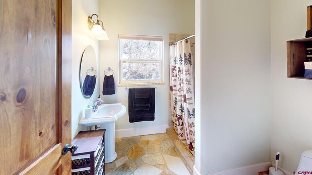 18812 Rd 27, Dolores, CO 81323 - bathroom with toilet, baseboards, curtained shower, and stone finish floor