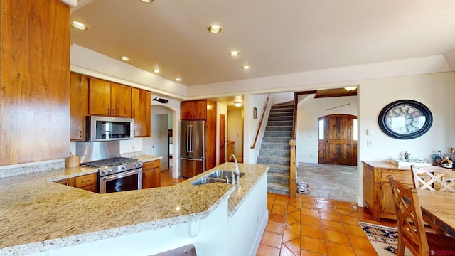 18812 Rd 27, Dolores, CO 81323 - kitchen with arched walkways, appliances with stainless steel finishes, brown cabinetry, and a sink