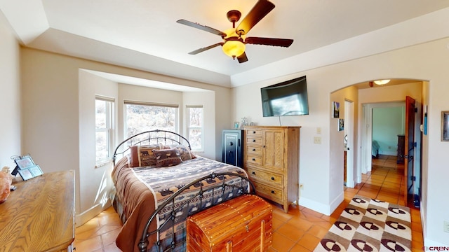 18812 Rd 27, Dolores, CO 81323 - bedroom featuring ceiling fan, arched walkways, light tile patterned floors, baseboards, and a tray ceiling