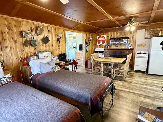 bedroom with freestanding refrigerator, wood finished floors, and wood walls