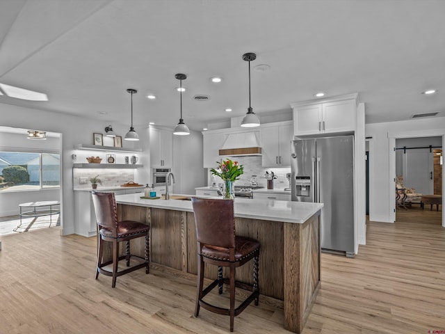 kitchen with appliances with stainless steel finishes, tasteful backsplash, light countertops, custom range hood, and recessed lighting