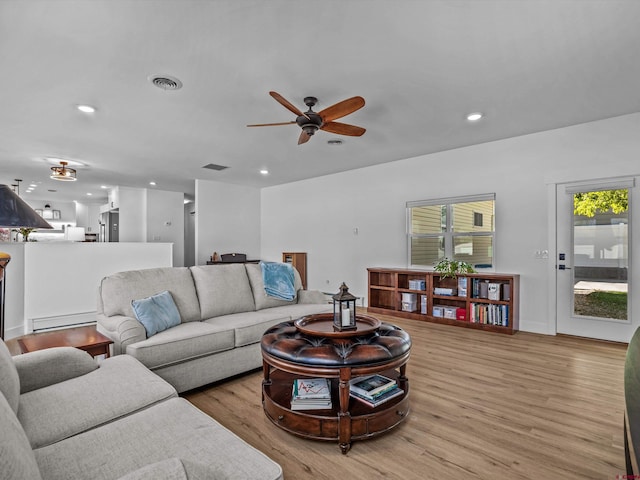 living room with visible vents, ceiling fan, recessed lighting, a baseboard heating unit, and light wood finished floors