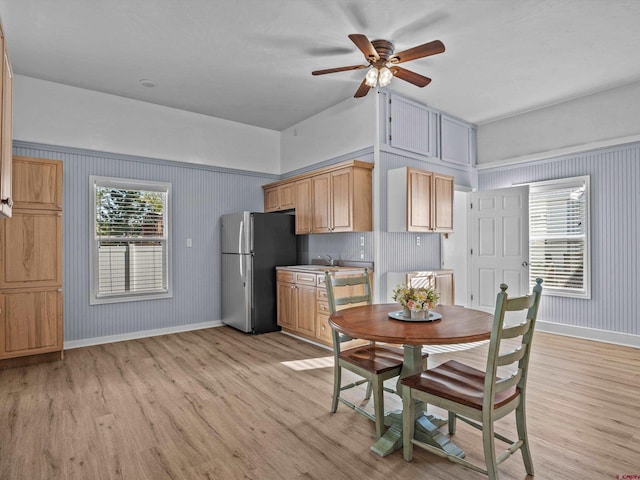 dining area featuring light wood-style floors, a ceiling fan, and baseboards