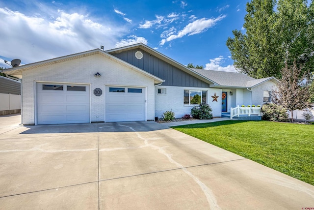 ranch-style house featuring a garage, a front yard, driveway, and brick siding