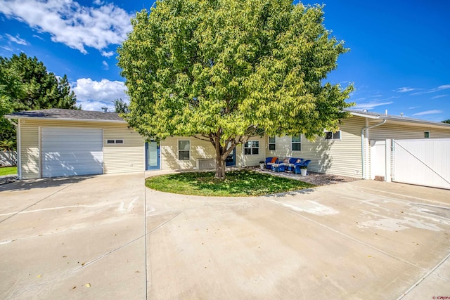 view of front of property with fence, an attached garage, driveway, and a gate