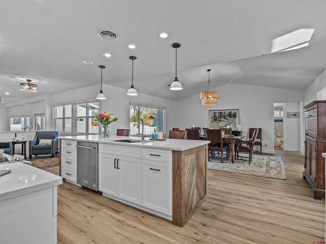 kitchen featuring visible vents, light wood-style floors, open floor plan, a sink, and dishwasher