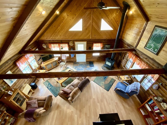 409 Sierra Vista Way, Gunnison, CO 81230 - living area featuring wooden walls, ceiling fan, a wood stove, high vaulted ceiling, and wood ceiling