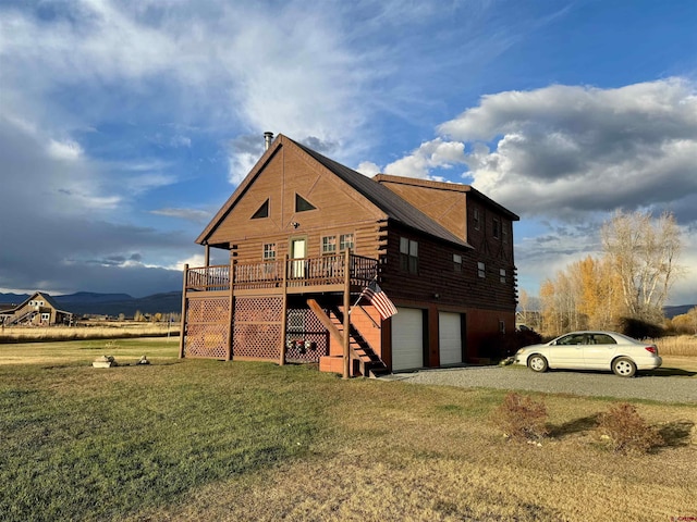 409 Sierra Vista Way, Gunnison, CO 81230 - view of property exterior featuring driveway, a deck, log siding, stairway, and a yard