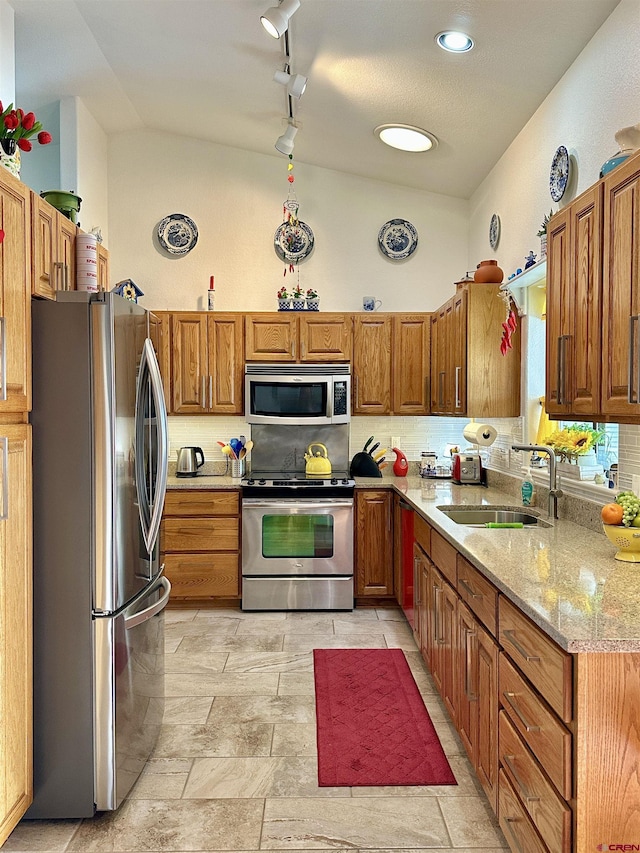 kitchen with a sink, appliances with stainless steel finishes, and brown cabinets