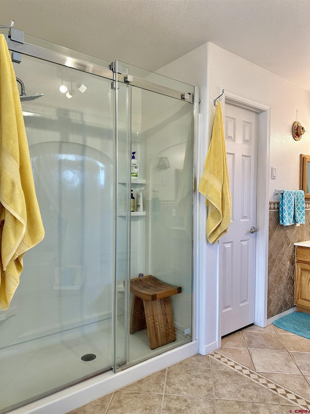bathroom with vanity, a shower stall, and a textured ceiling